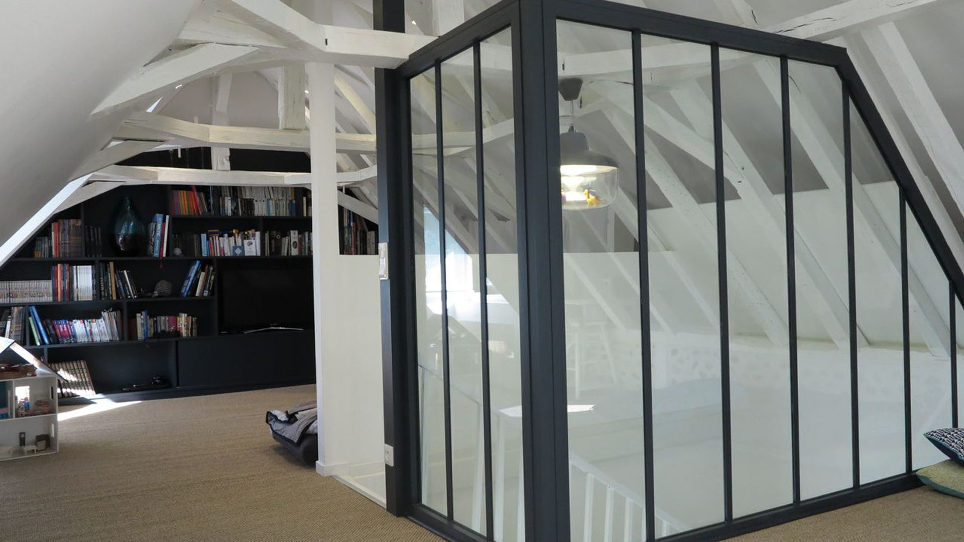 Aménagement des combles pour créer un espace de vie lumineux et polyvalent, tout en valorisant les éléments architecturaux.