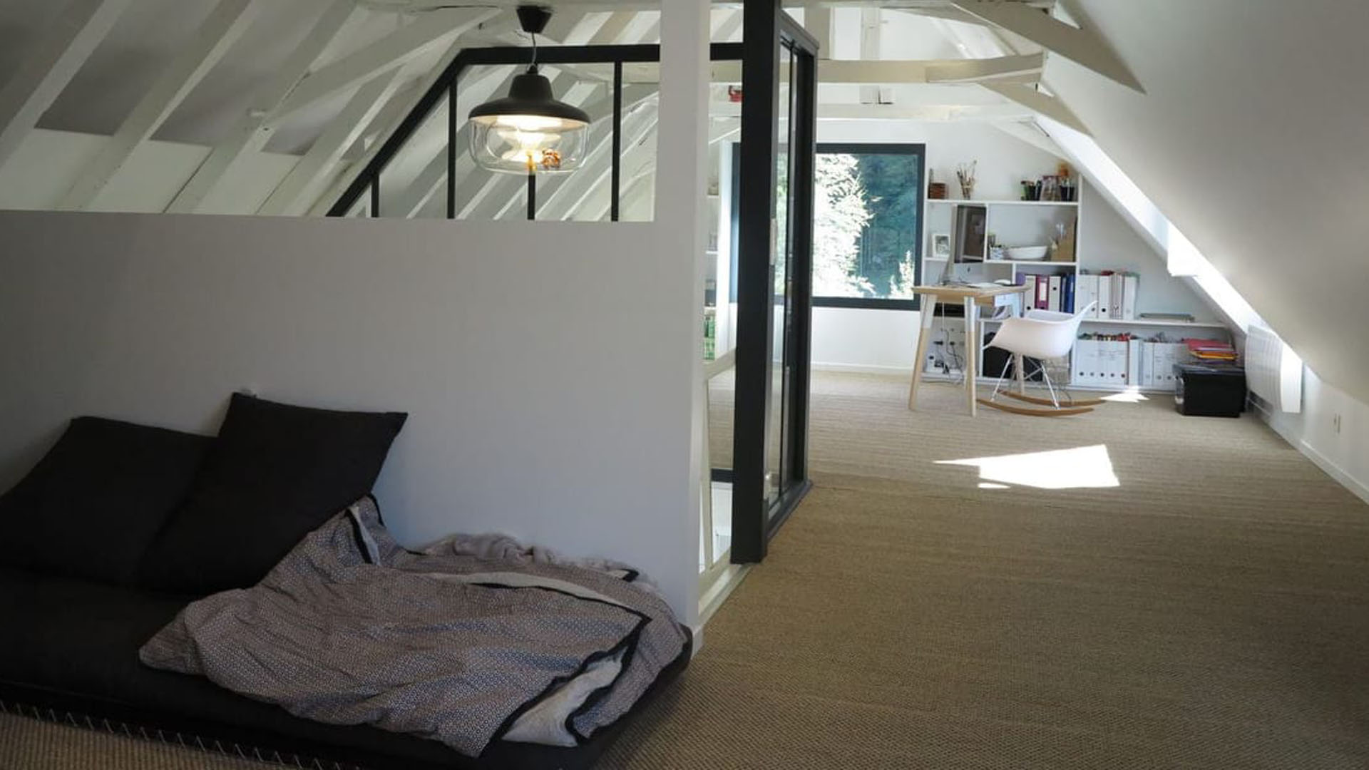 Aménagement des combles pour créer un espace de vie lumineux et polyvalent, tout en valorisant les éléments architecturaux.