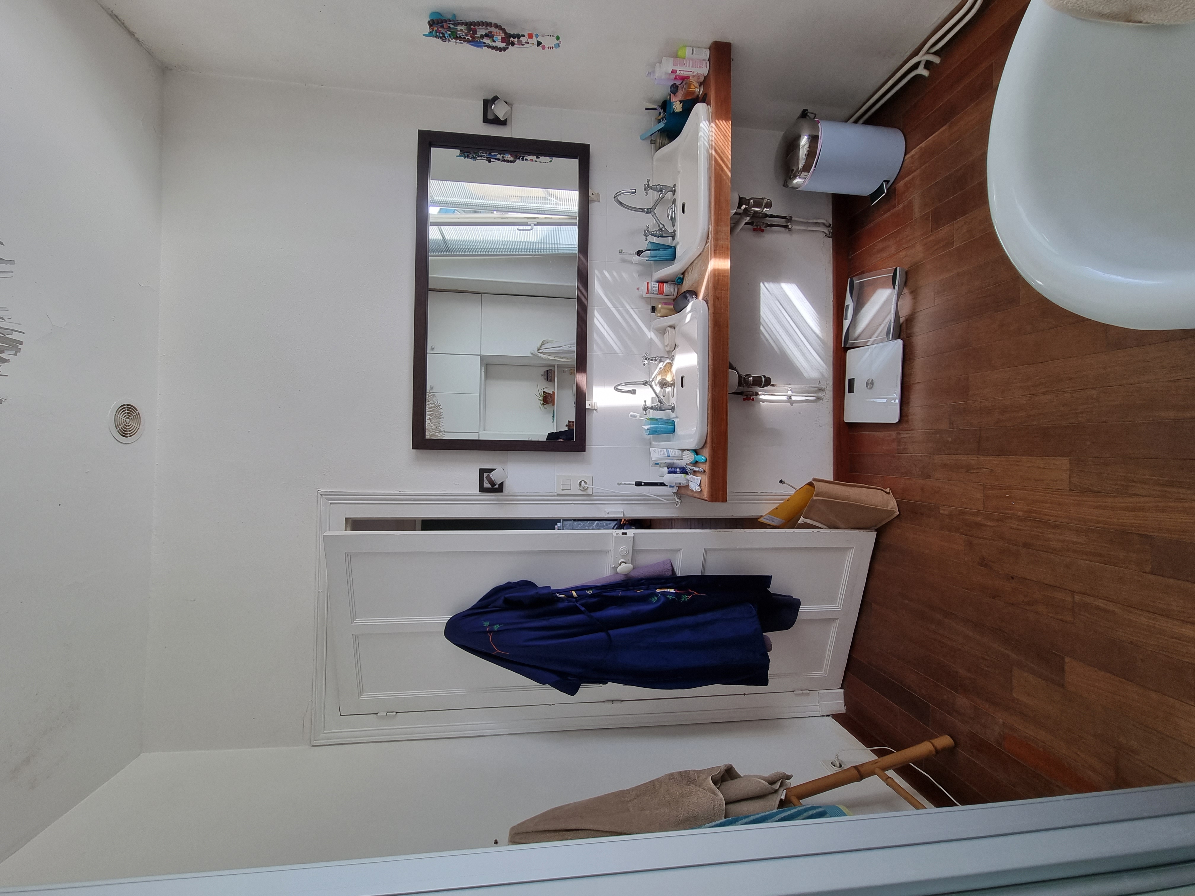 Rénovation d'une salle de bain à Pau : terrazzo, bois et robinetterie noire pour un espace spa élégant et fonctionnelle.