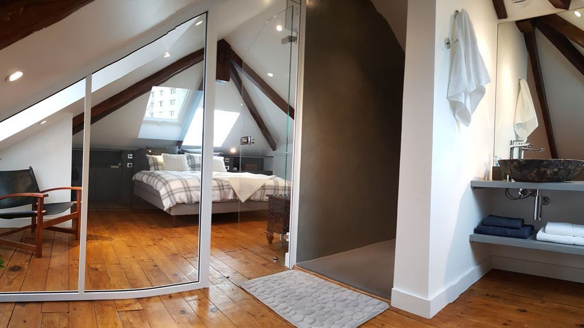 Aménagement d'une suite parentale sous combles : dressing sur mesure, salle de bain et atmosphère cocooning.